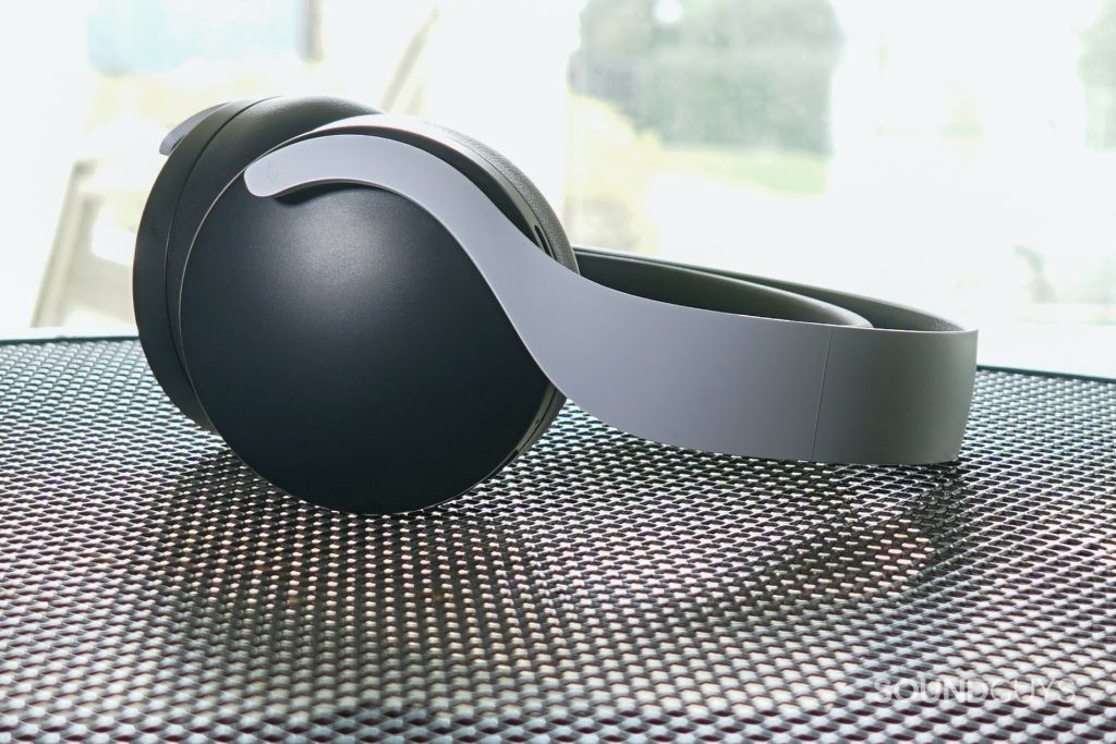 The Sony Pulse 3D wireless headset lays on a wireframe table in front of a window.