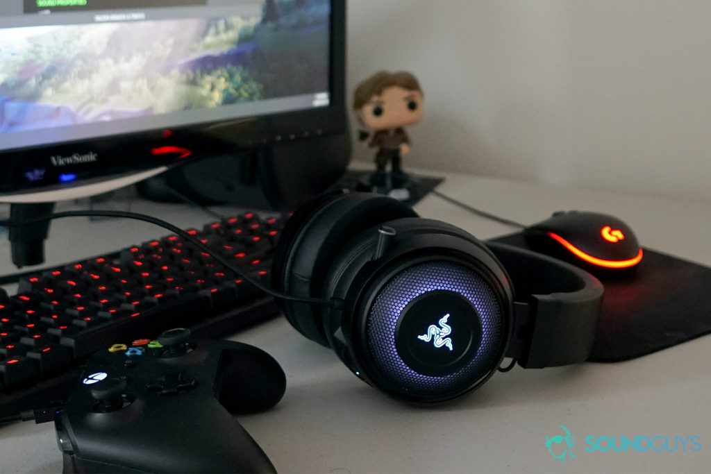 The Razer Kraken Ultimate sits in front of a PC and an Oculus Quest, with an Xbox One controller nearby, and a han solo statue in the background.