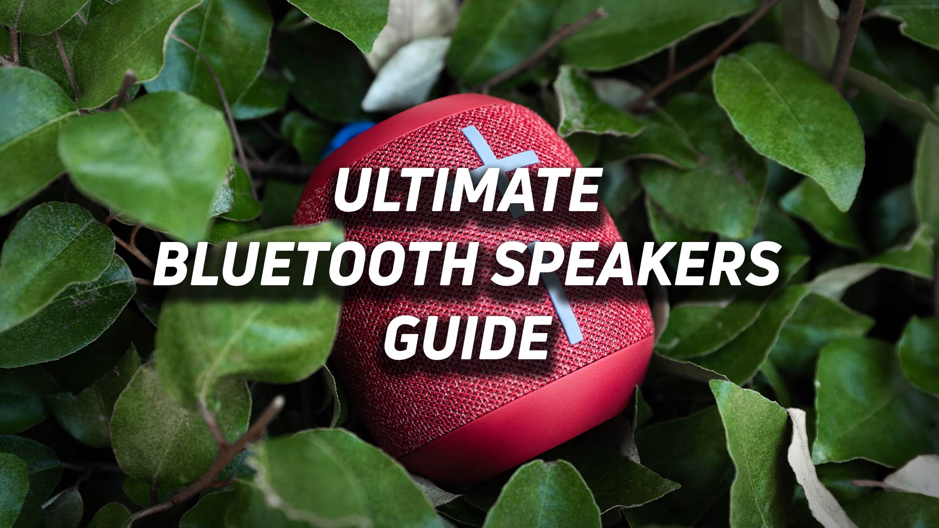 The UE WONDERBOOM 2 Bluetooth speaker in red against a green leafy background with the phrase "Ultimate Bluetooth speakers guide" overlaid on top of it.
