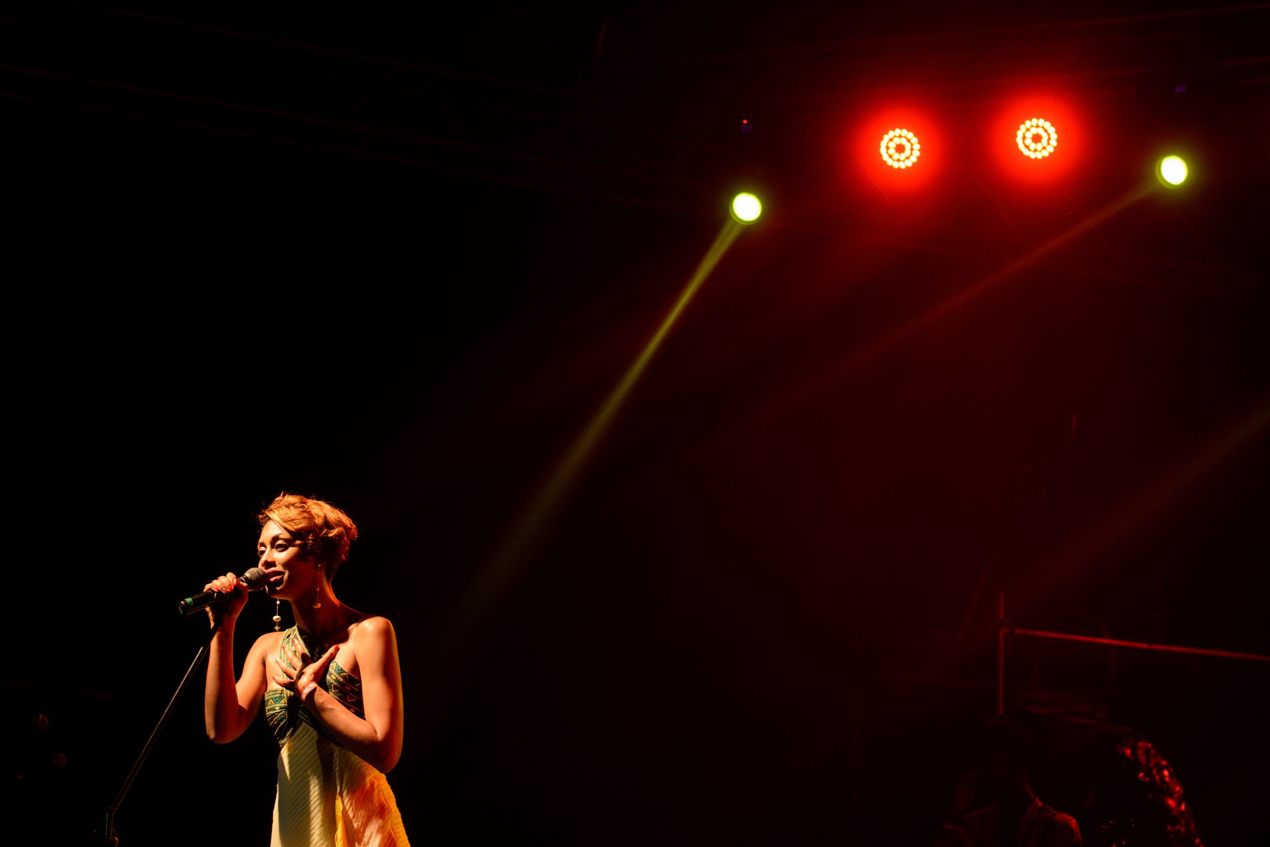 A woman singing into a microphone on a stage.