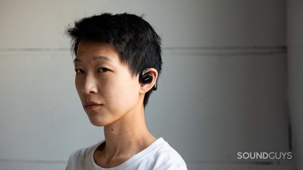 A woman wears the Bose Sport Open Earbuds.