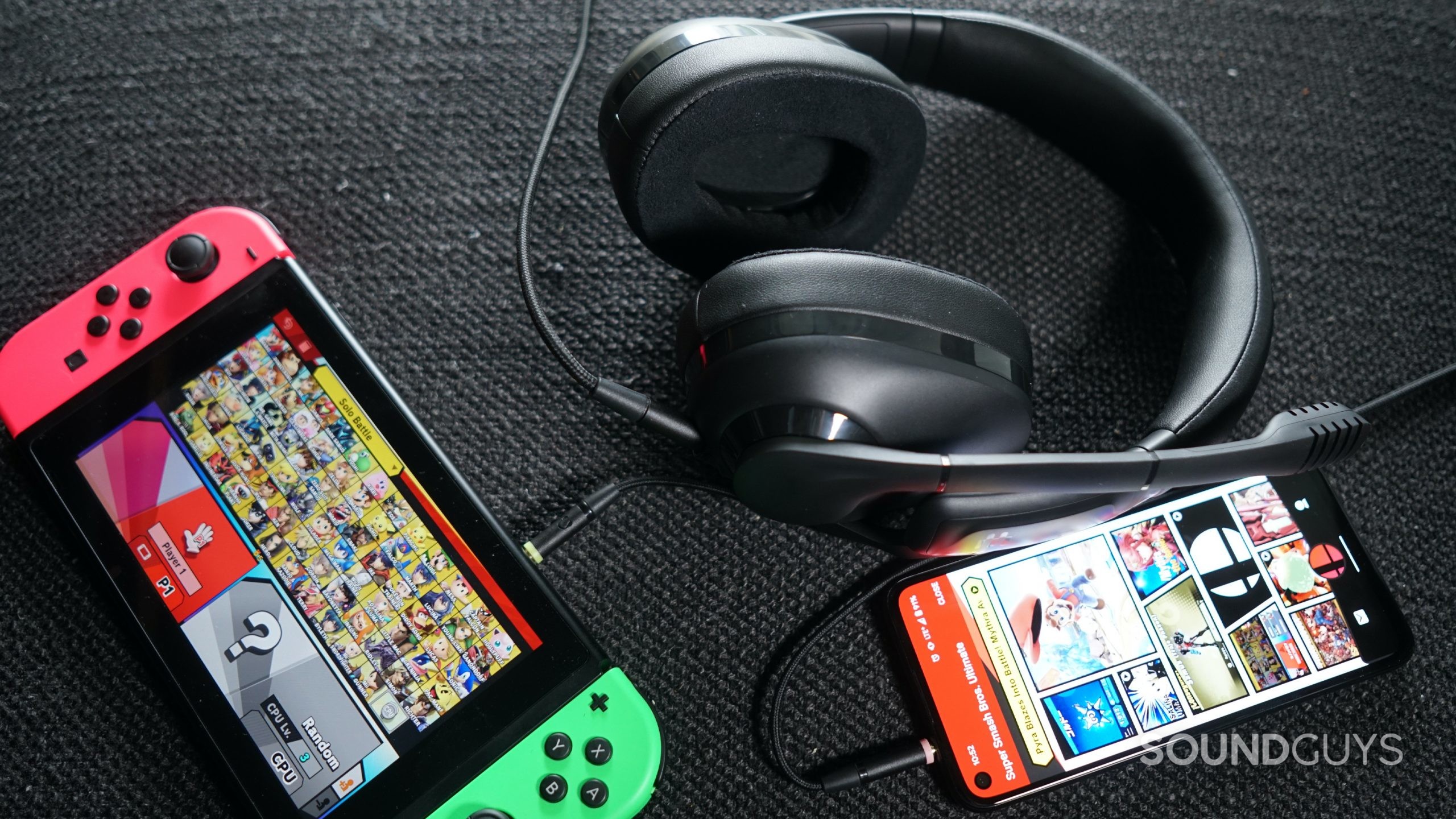 The EPOS H3 gaming headset lays on a fabric surface plugged into the Nintendo Switch and Google Pixel 4a running the Nintendo Switch voice chat app