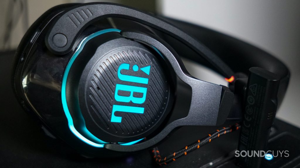The JBL Quantum 800 lays on top of a PC with its USB dongle plugged in.