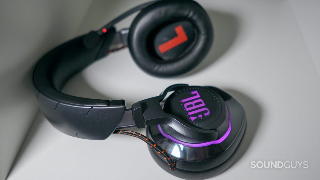 The JBL Quantum 800 lays on a white shelf with its microphone muted.