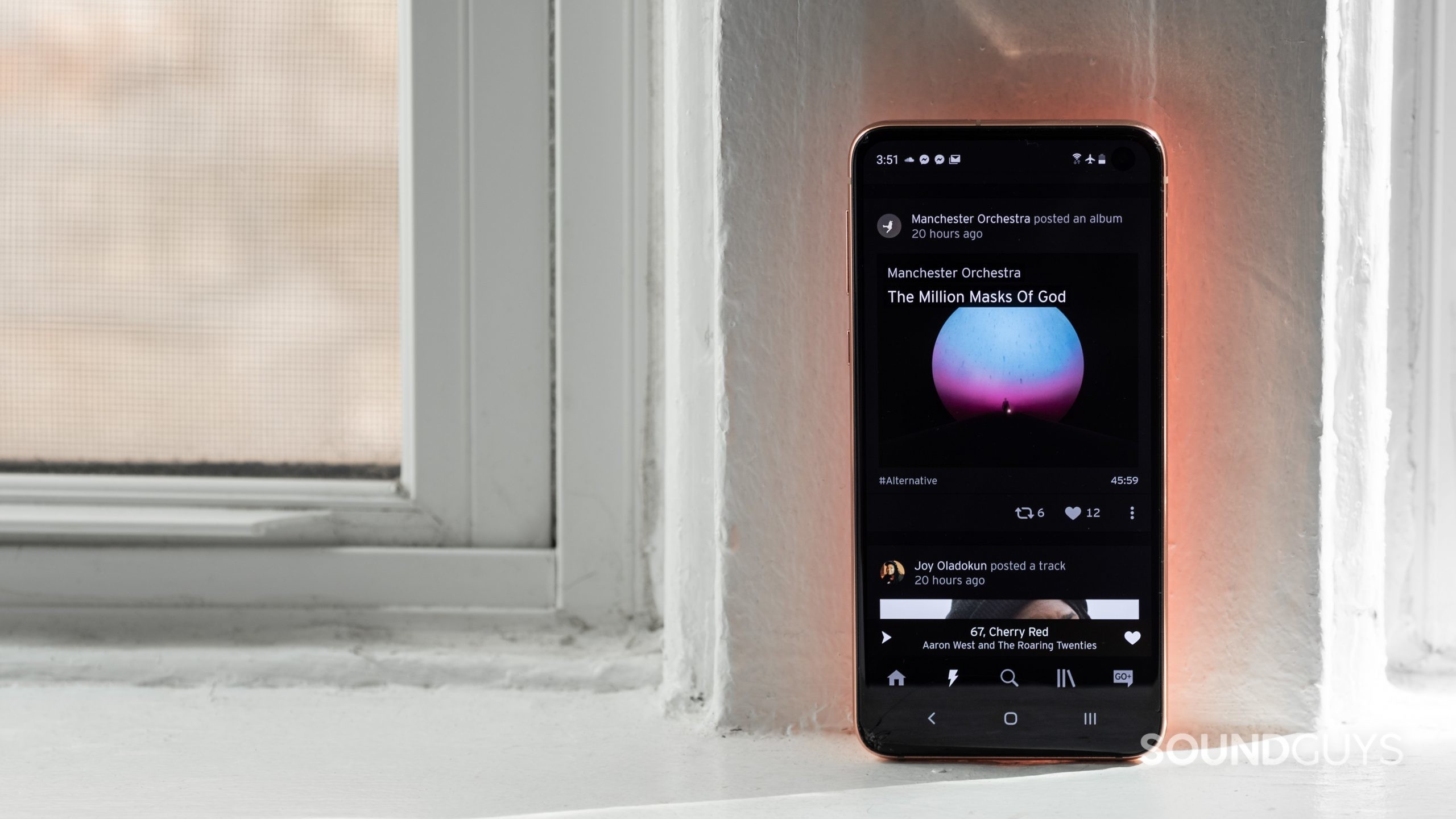 The SoundCloud mobile app on a vertical, free-standing smartphone.