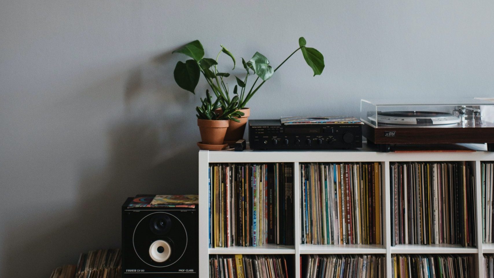 Collection of vinyl records on shelf in apartment.