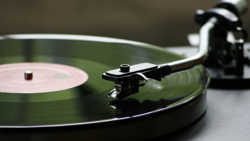A turntable with a green vinyl record on top of it.