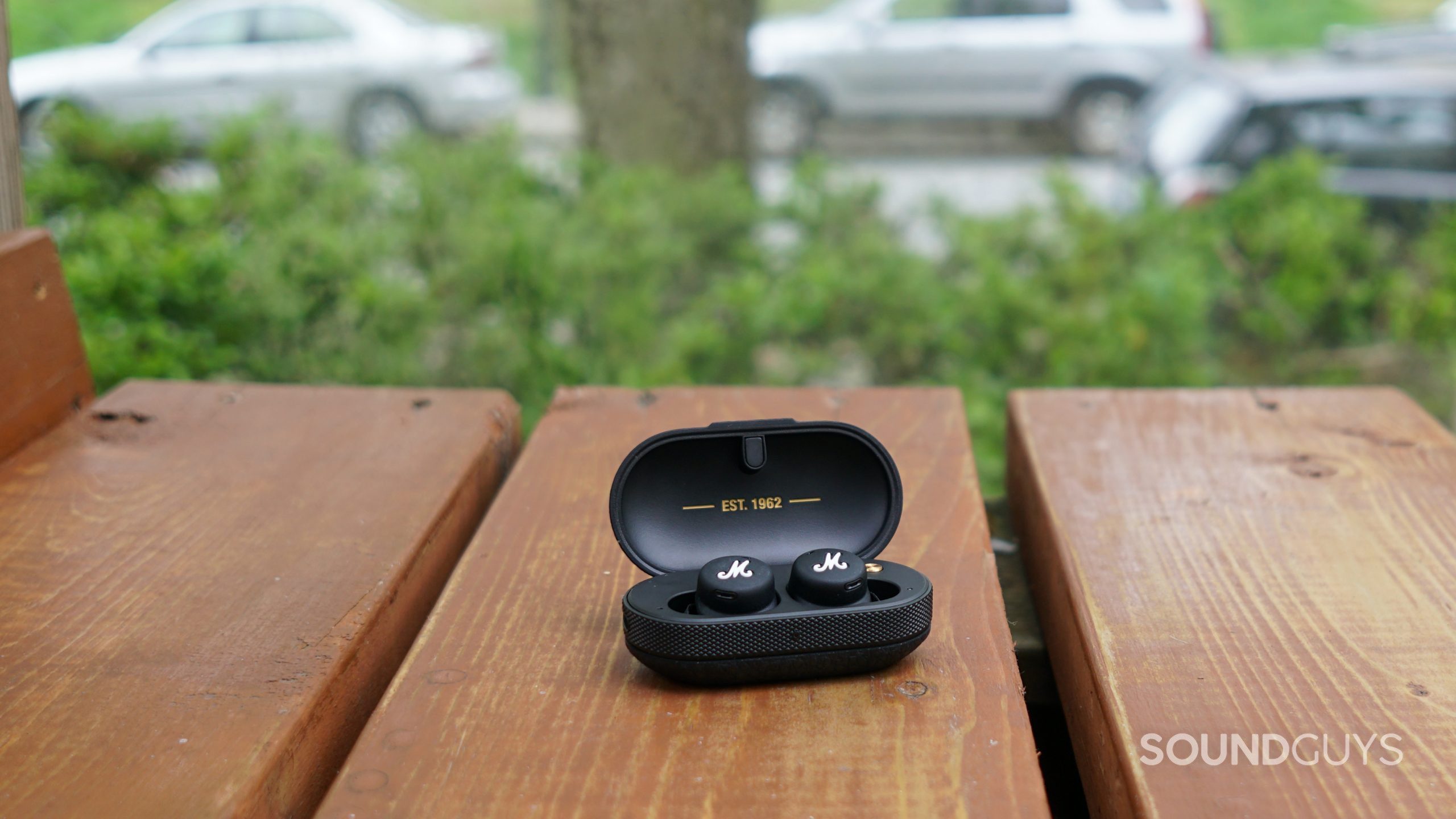 Marshall Mode II Case open 2 The Marshall Mode II true wireless earbuds sit in their charging case on a woode surface.