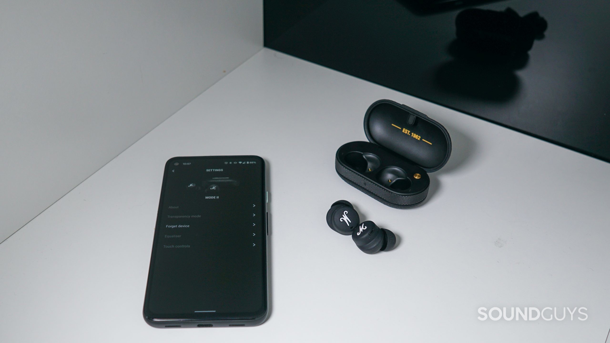 Marshall Mode II app shot The Marshall Mode II true wireless earbuds sit outside their charging case next to a Google Pixel 4a runnin the Marshall Bluetooth app.