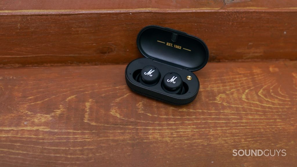 The Marshall Mode II true wireless earbuds sits in its charging case on a woode surface