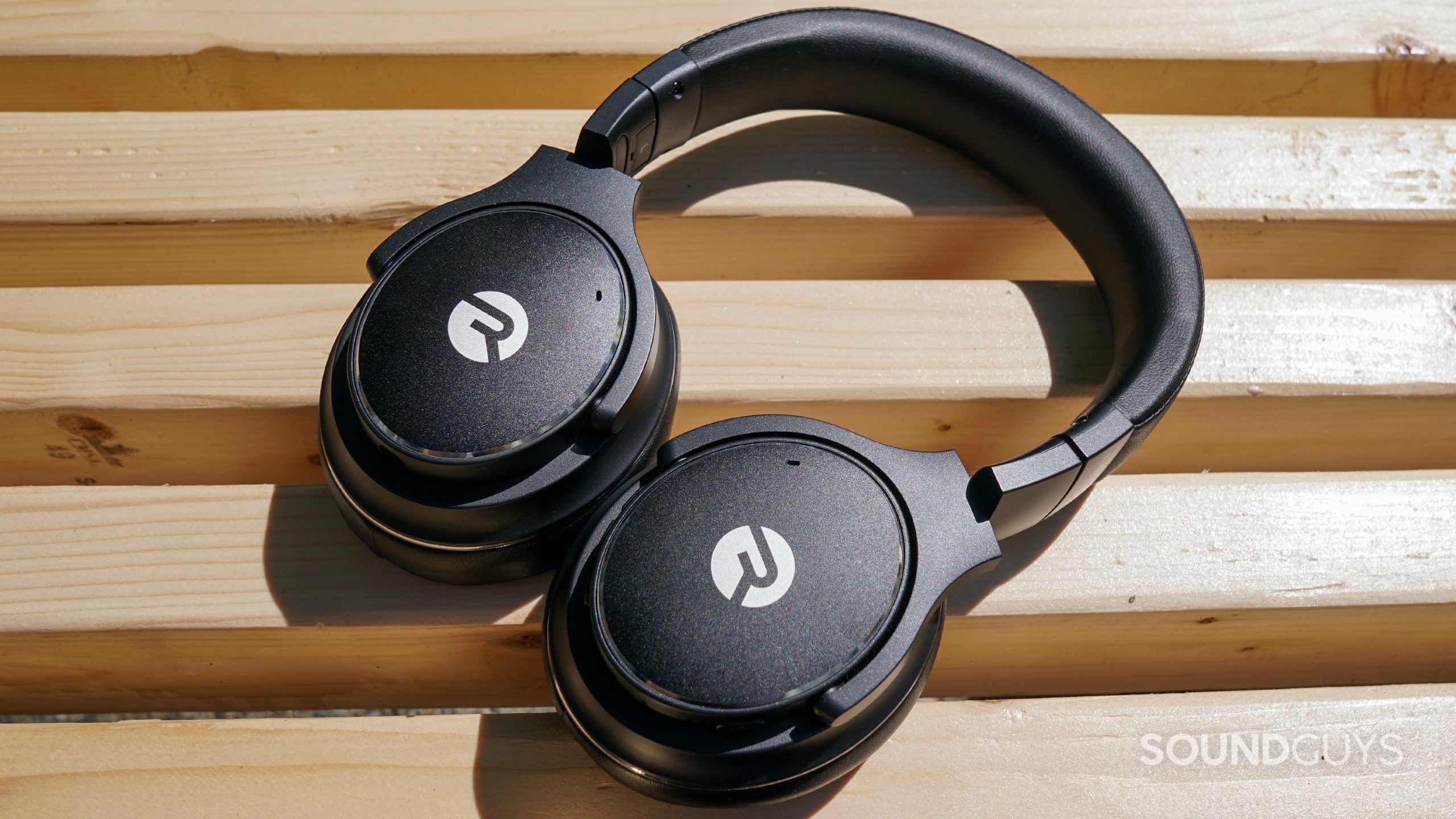 Raycon Everyday Headphones 2021 bench shot 2 The Raycon Everyday Headphones lay on a wooden bench.