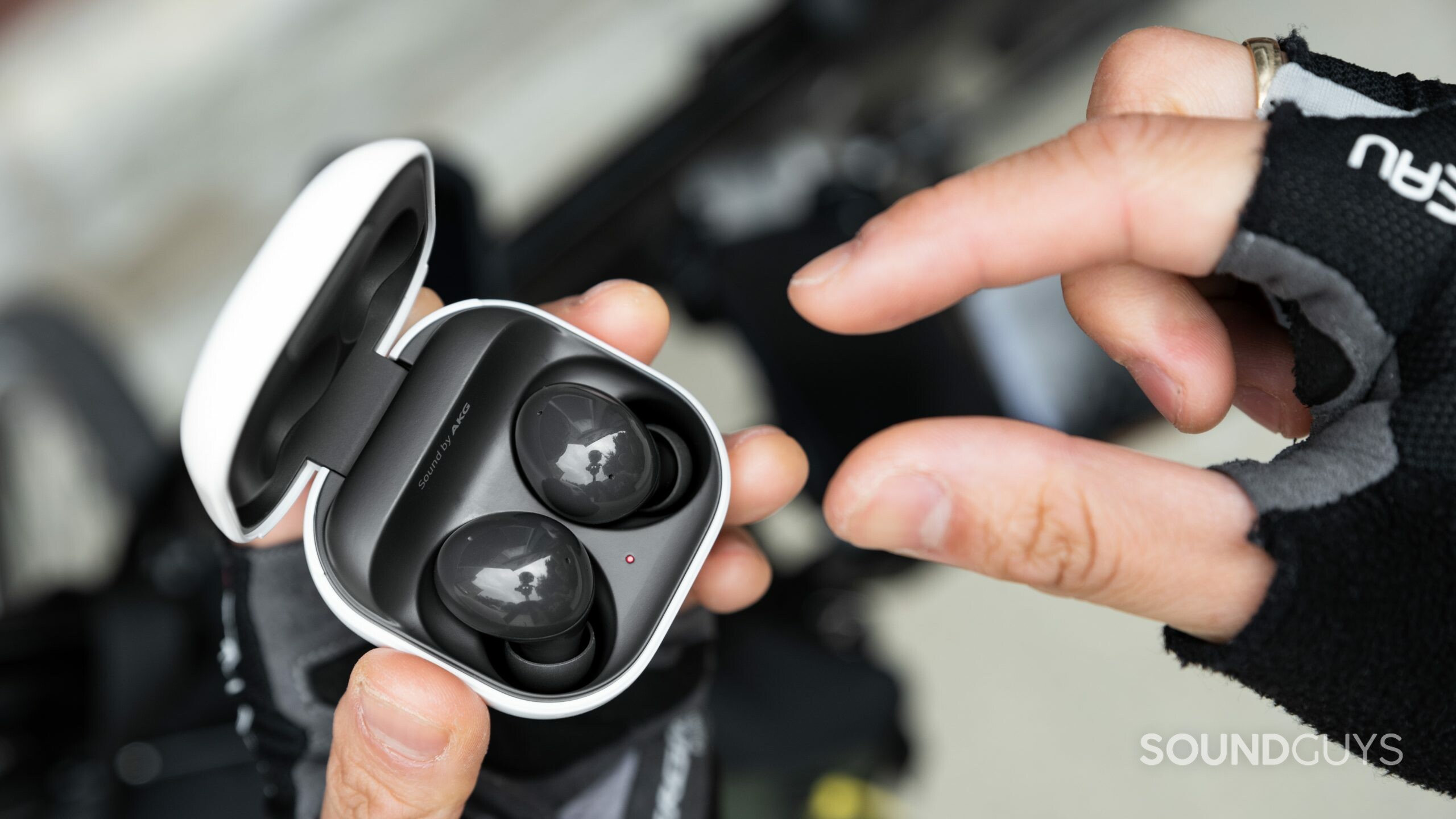 A hand reaches to remove one Samsung Galaxy Buds 2 noise canceling true wireless 2 earbud from the case.