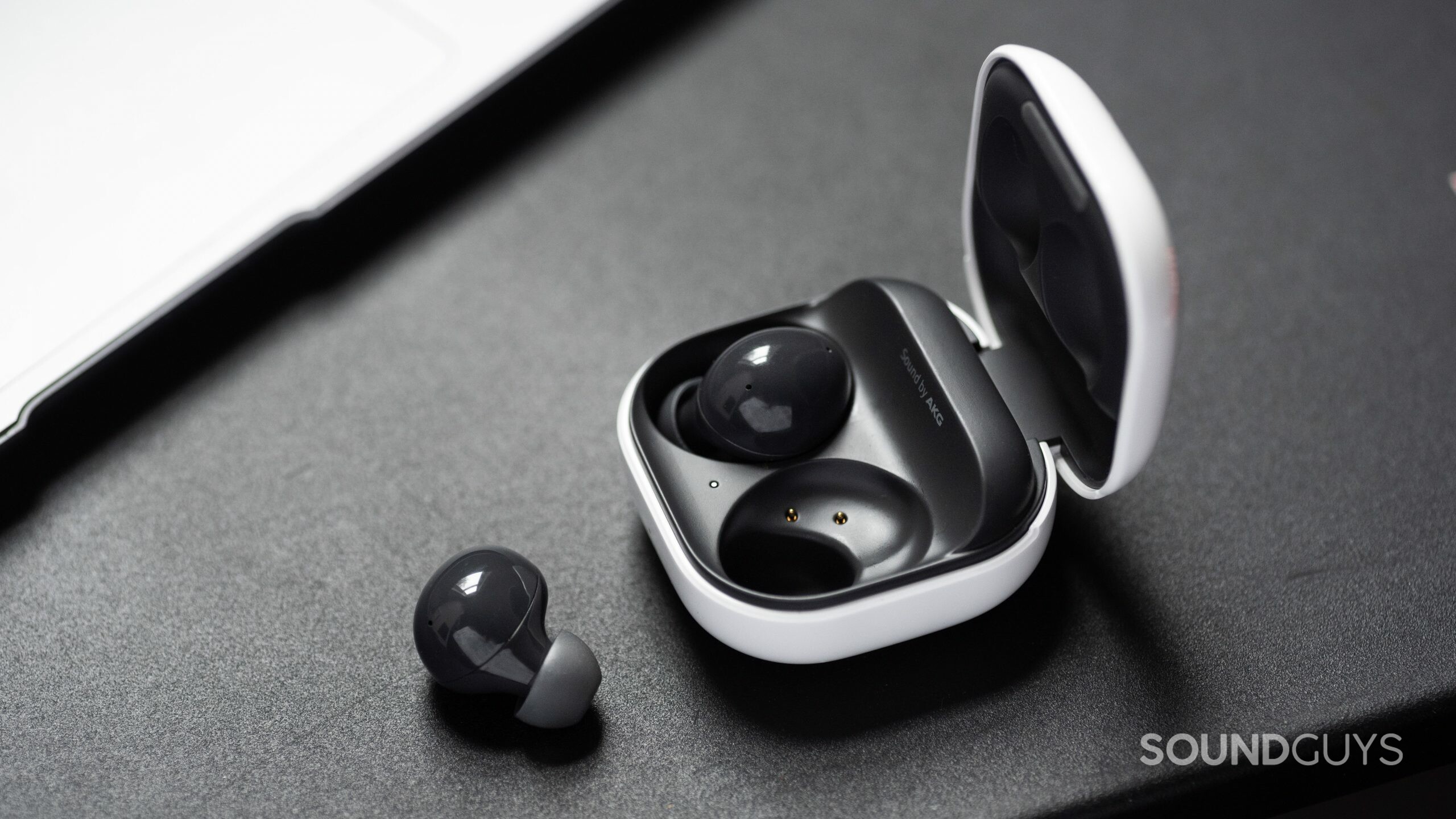 The Samsung Galaxy Buds 2 noise canceling true wireless earbuds with one 'bud out of the open, angled charging case.