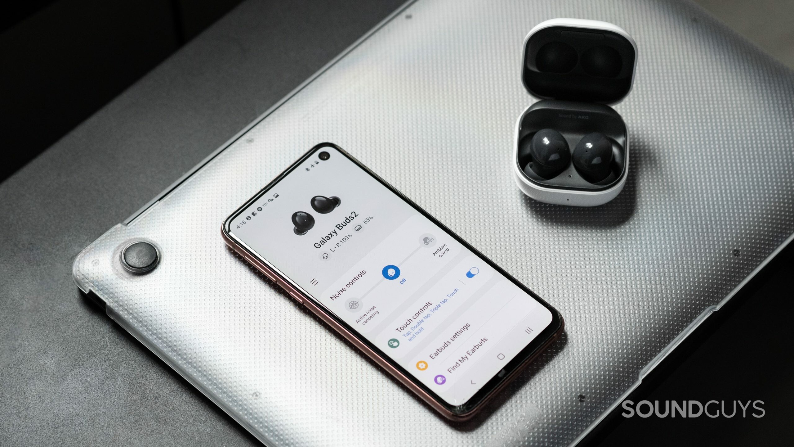 The Samsung Galaxy Buds 2 noise canceling true wireless earbuds in the open charging case while connected to the Galaxy Wearable app on a Samsung Galaxy S10e.
