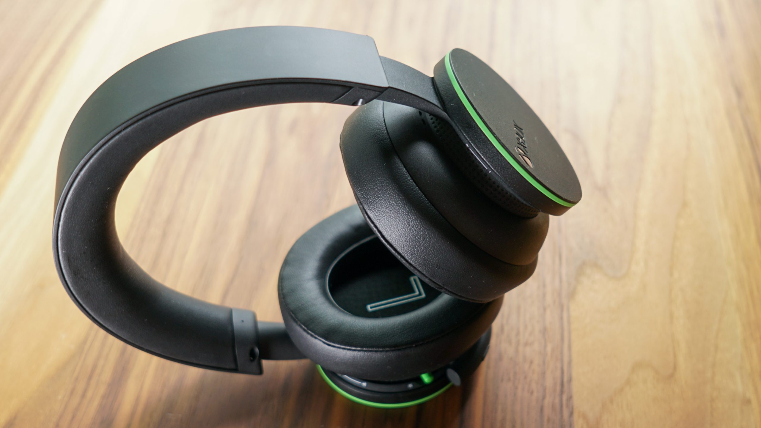 The Xbox Wireless Headset sits on a wooden table with its controls displayed.