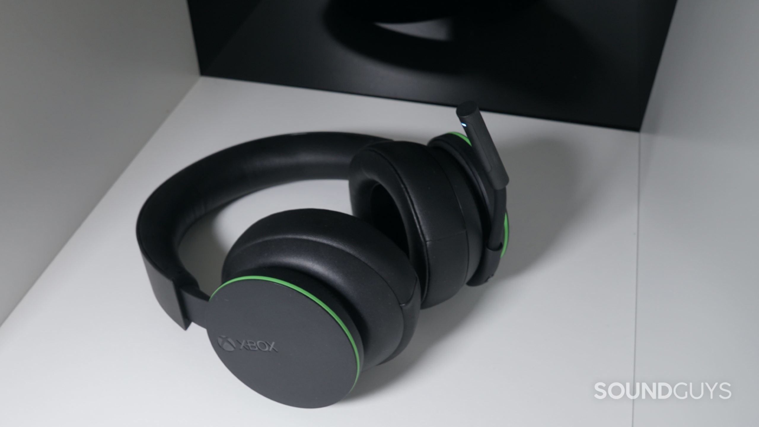 The Microsoft Xbox Wireless Headset lays on a white shelf with a reflective surface behind it.