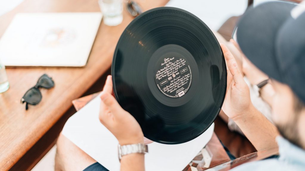 Person holding up and inspecting a vinyl record