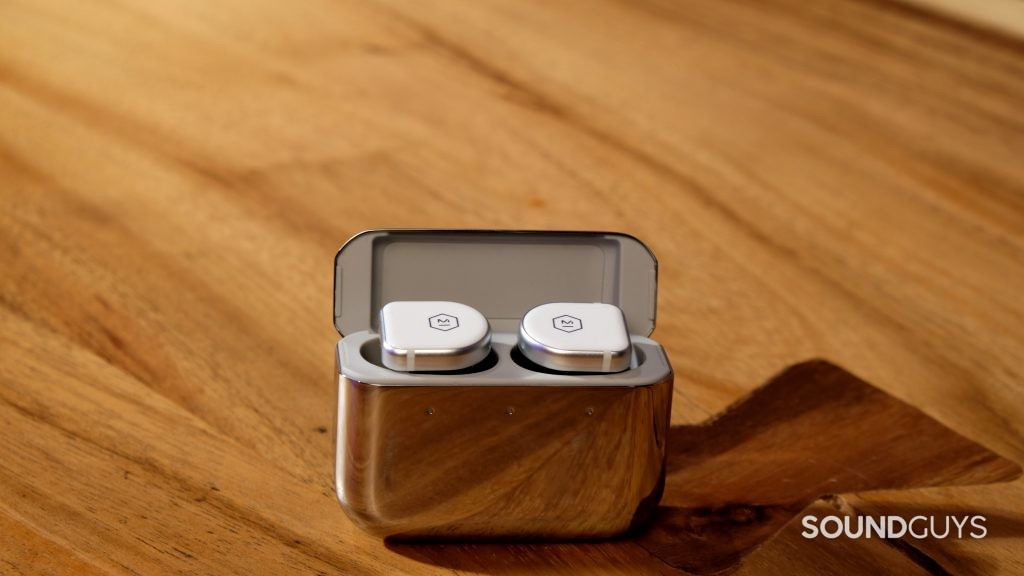 The Master & Dynamic MW08 true wireless noise cancelling earbuds rest in the mirrored charging case.