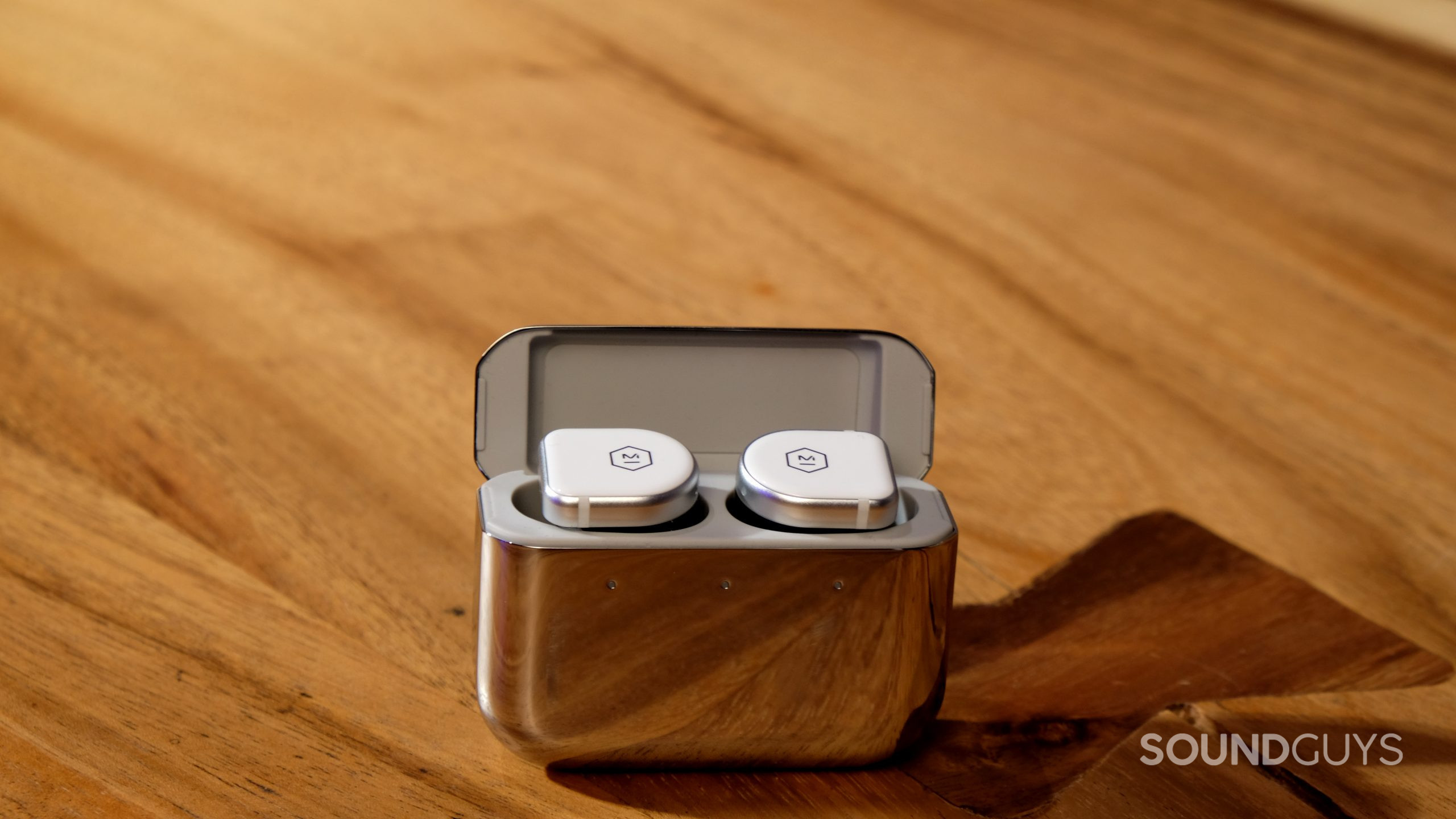 The Master &amp; Dynamic MW08 true wireless noise canceling earbuds rest in the mirrored charging case.
