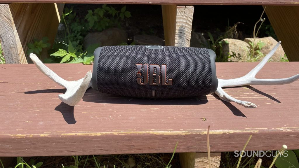 JBL Charge 5 resting on a wooden step with deer antlers next to it.