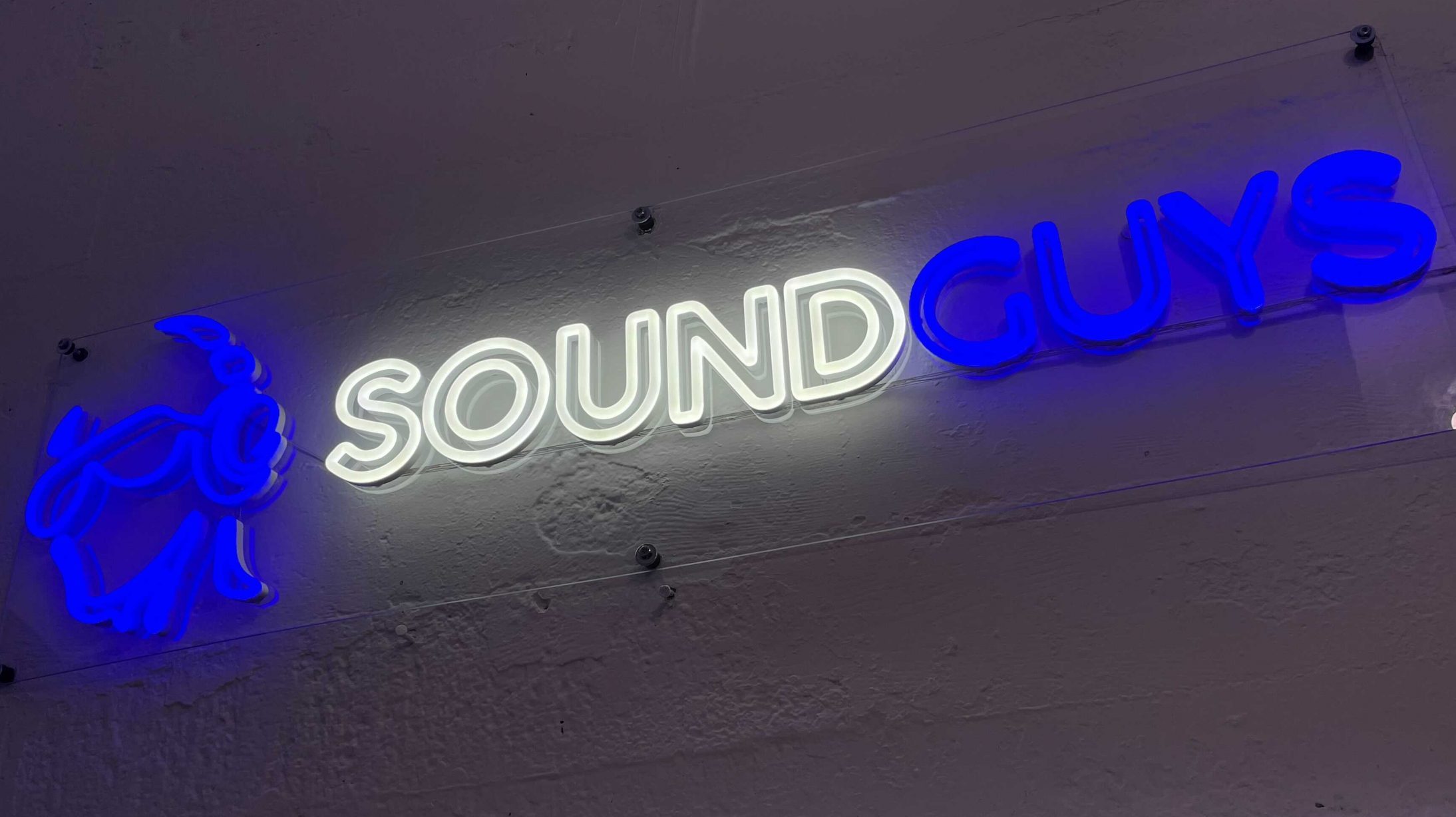 SoundGuys neon sign glows on the wall.