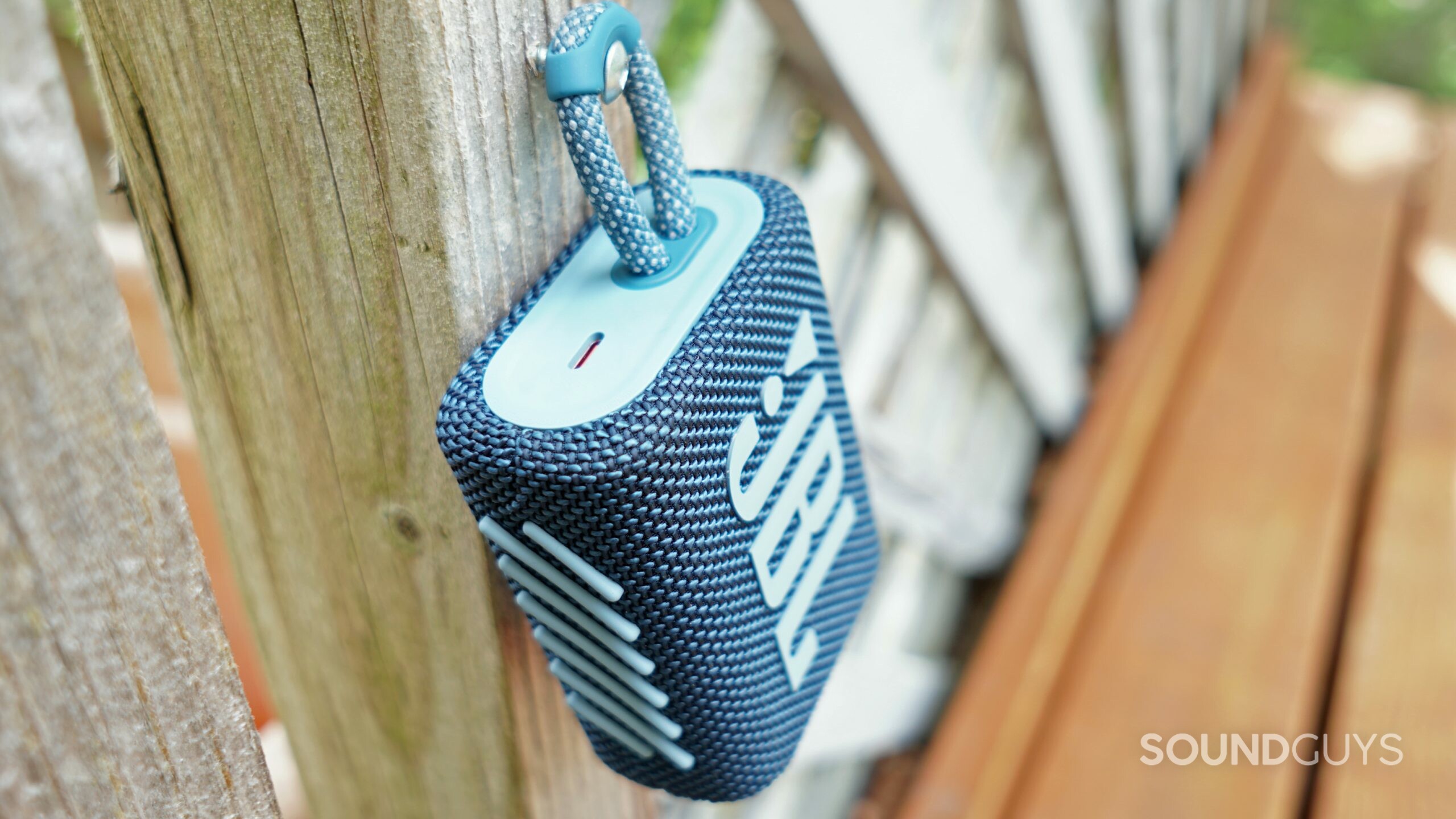 JBL-Go-3-hanging The JBL Go 3 hangs from a screw on a wooden patio divider.