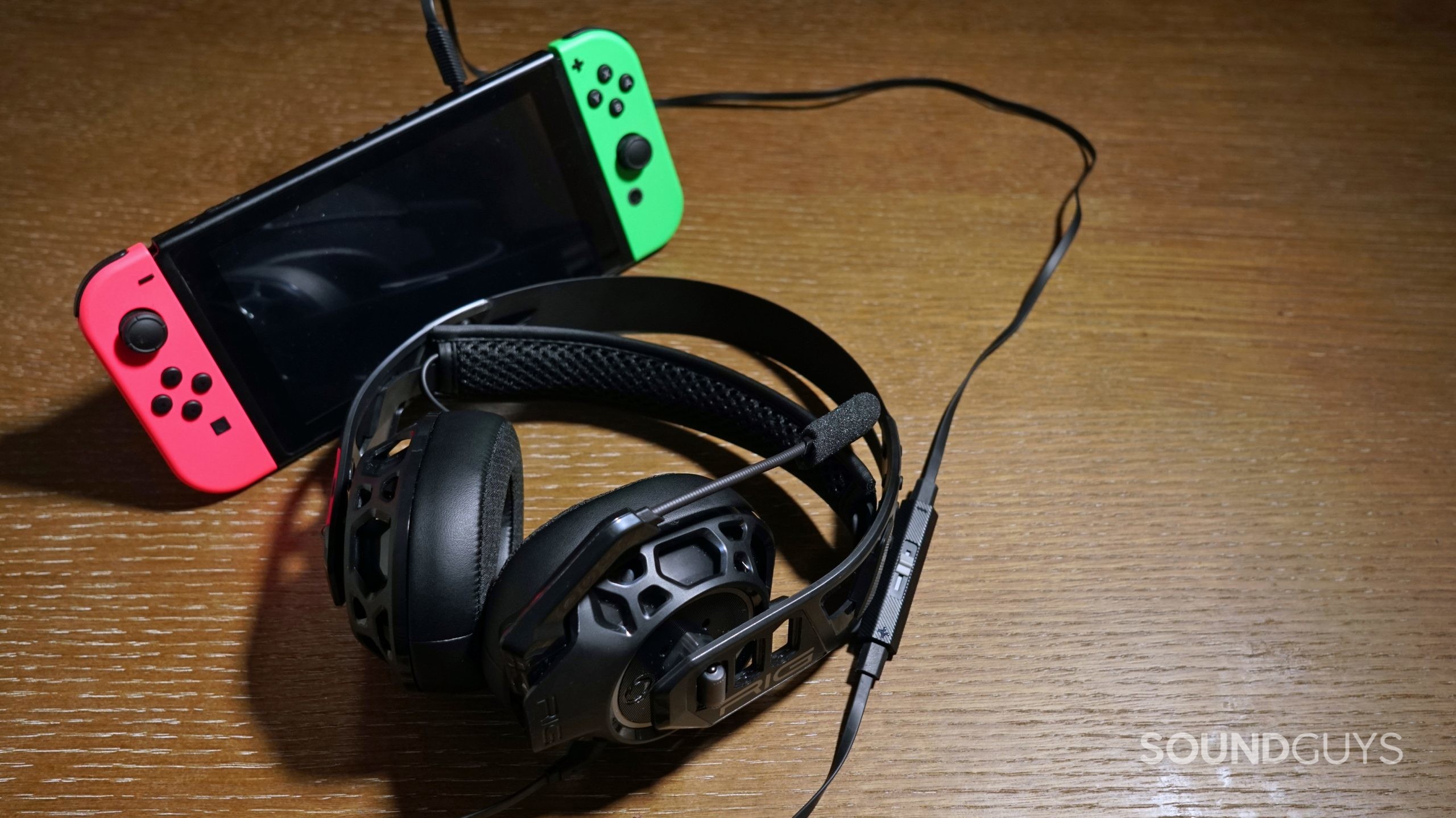 The Nacon RIG 500 Pro HC gaming headset lays on a wooden table plugged into a Nintendo Switch.