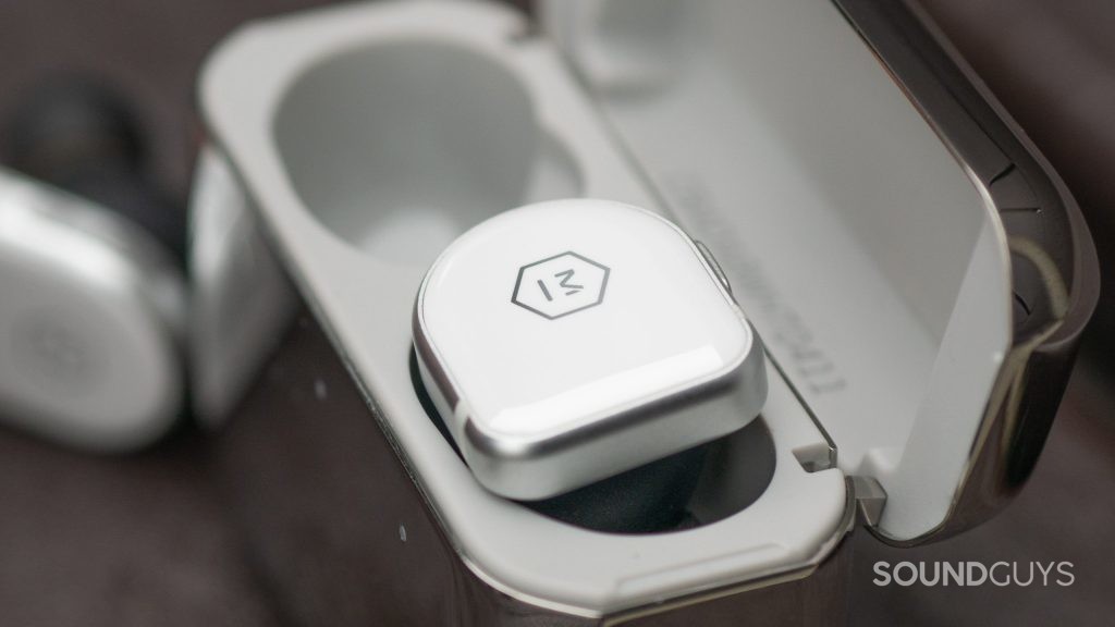 This macro photo shows the Master & Dynamic MW08 earbud in the battery case.