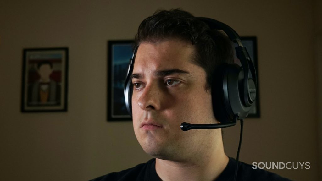 A man sits at a computer wearing the Turtle Beach Recon 500 gaming headset.