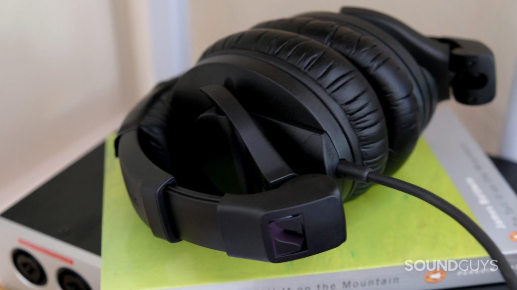 The Sennheiser HD 280 Pro studio headphones folded on a green book with the cable in full view.