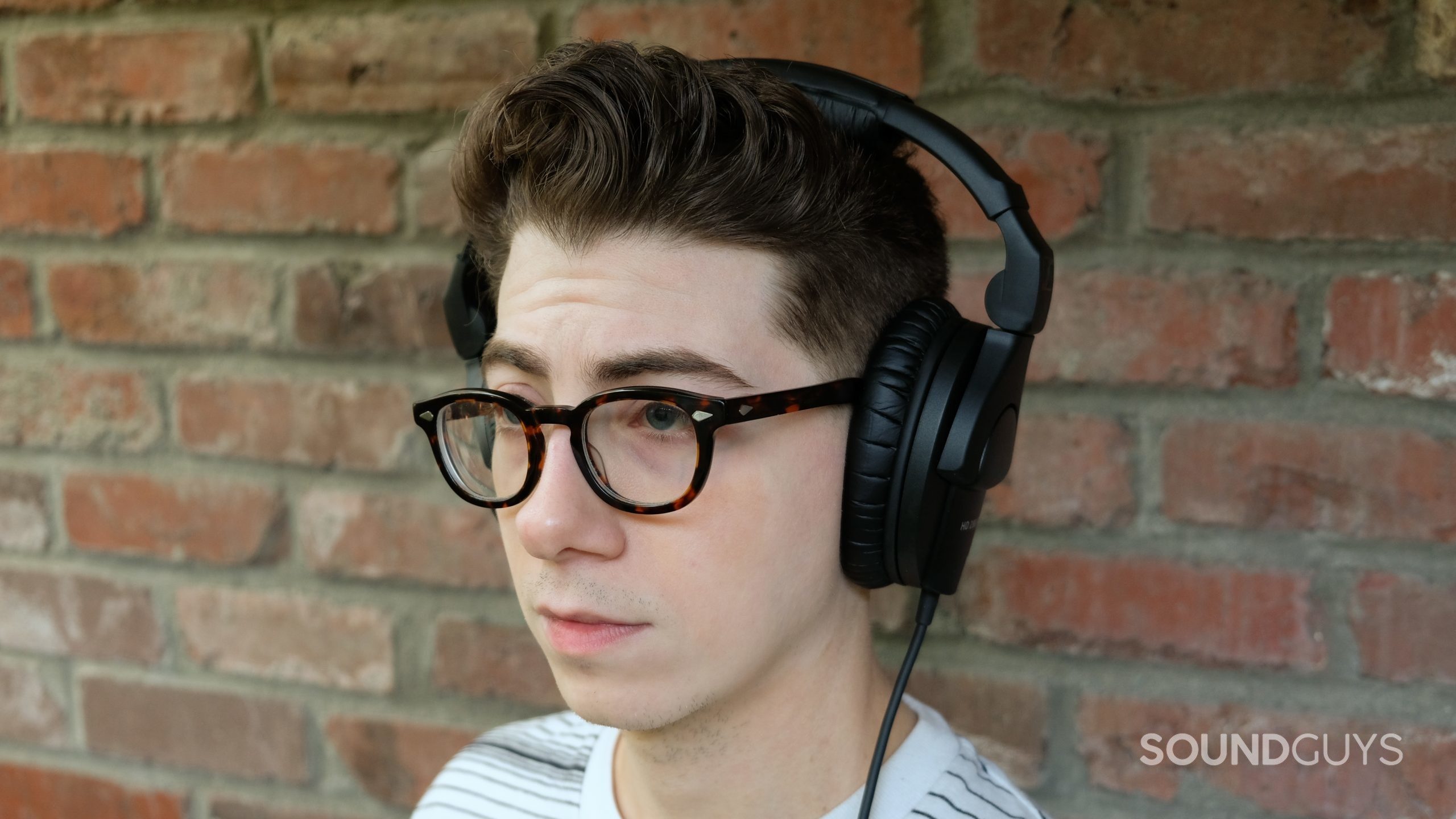 Sennheiser hd 280 pro headshot A man wears the Sennheiser HD 280 Pro studio headphones in front of a brick wall.