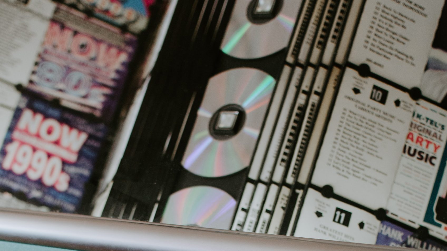 CDs seen through the window of a CD playing jukebox machine.