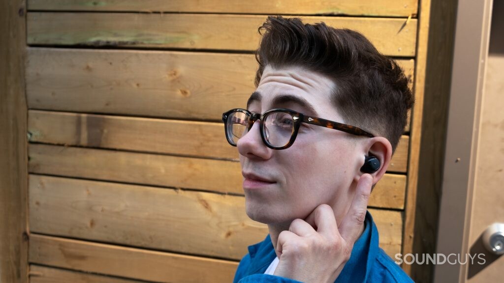 A bemused man wears the Anker Soundcore Life A1 earbud outside.