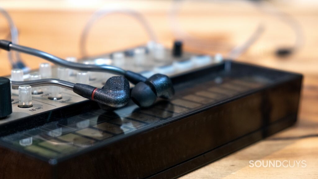 The Sennheiser IE 300 shot with a shallow depth of field, rest on a synthesizer.