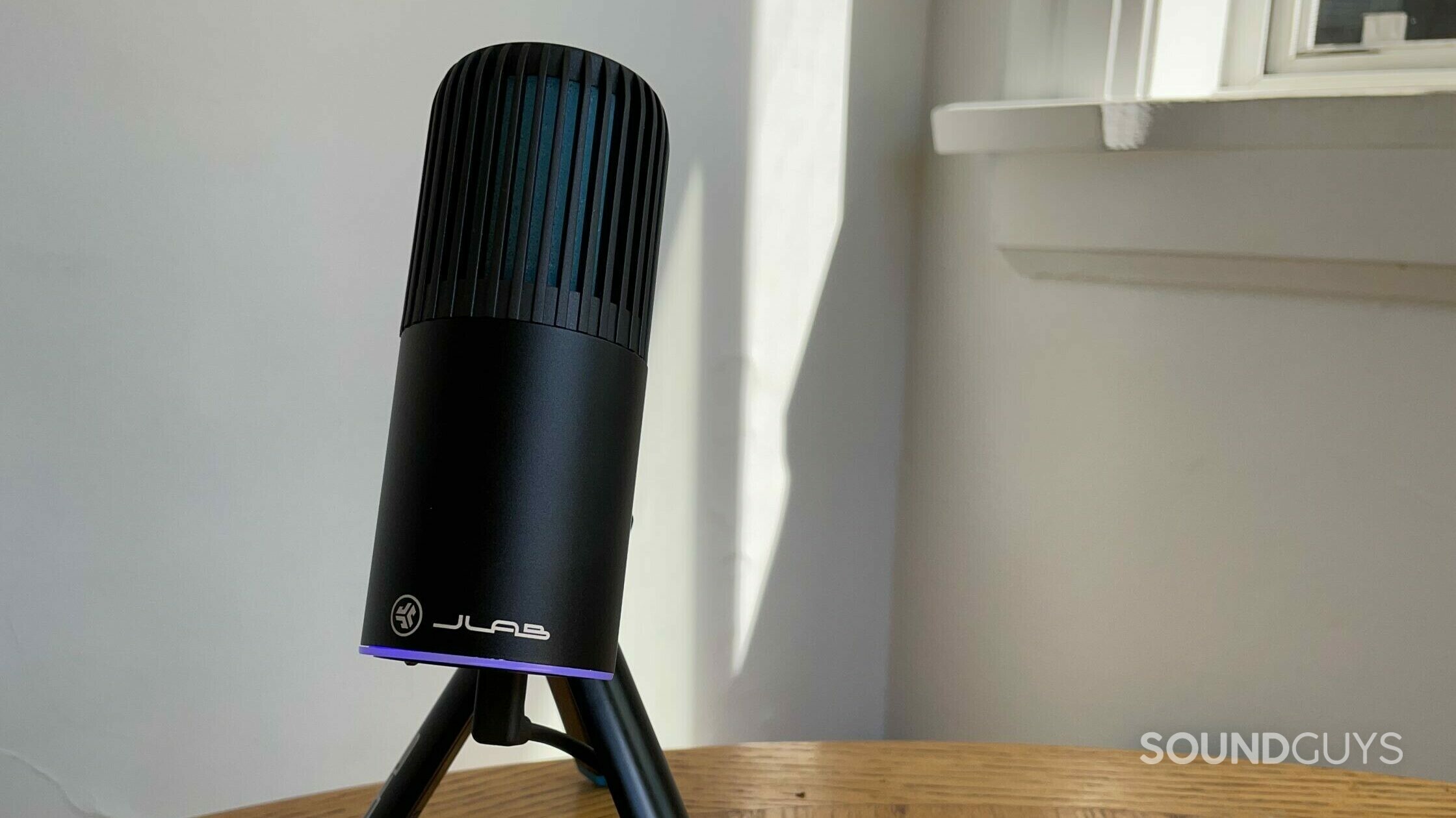 JLab Talk Go USB Microphone in black on a wooden table.