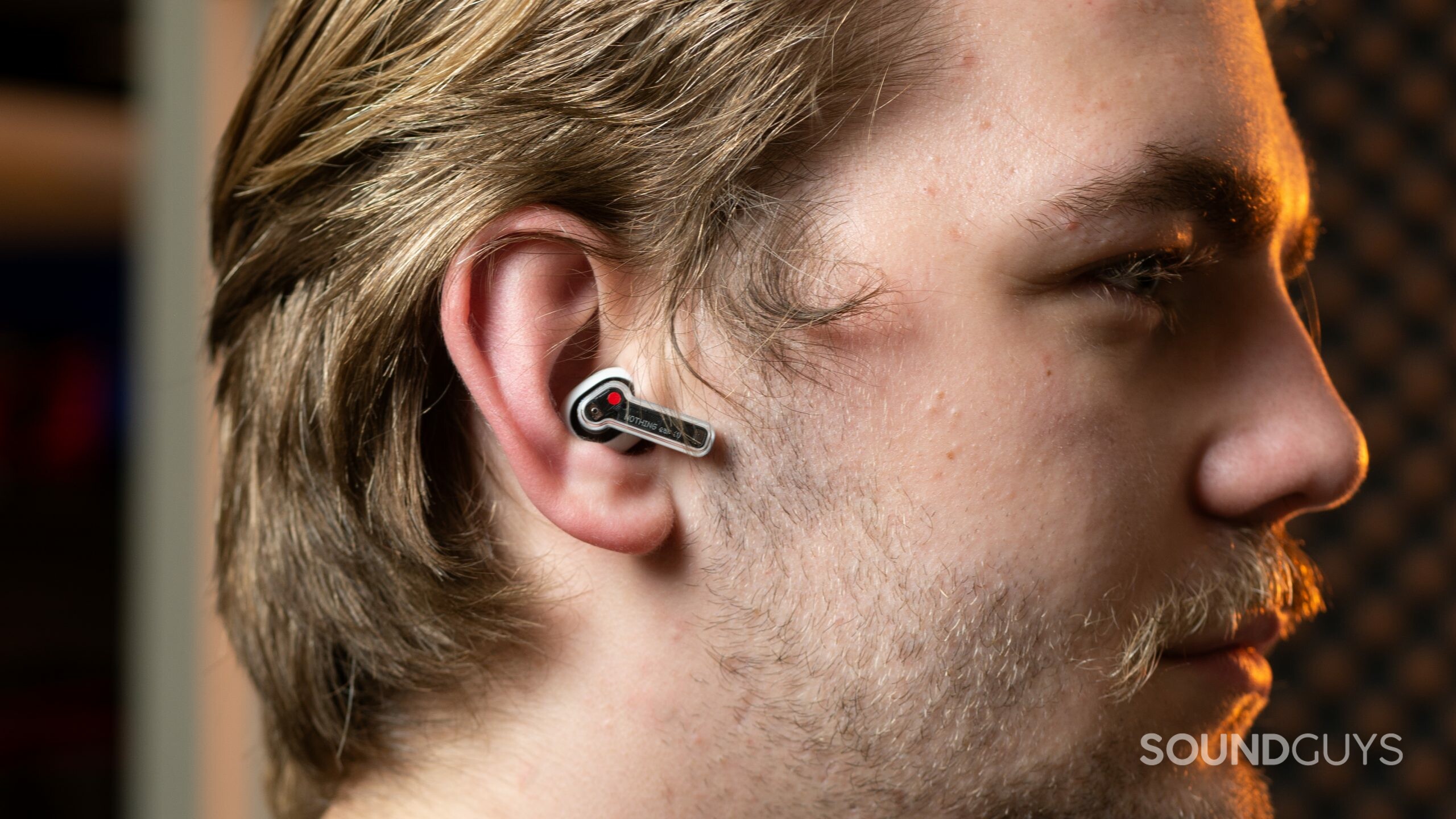 A man in profile wears the Nothing Ear 1 noise canceling true wireless earphones.