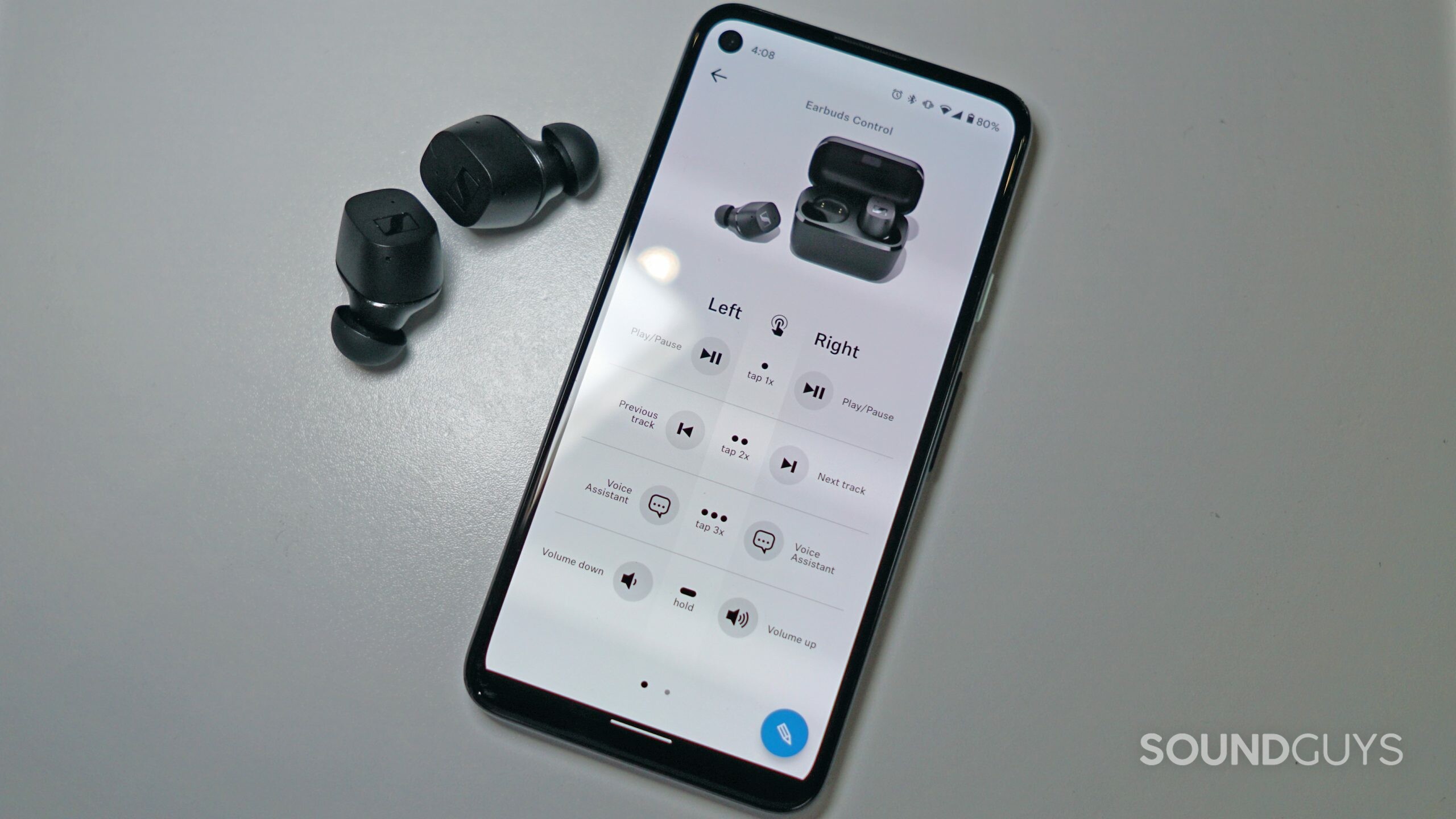 The Sennheiser CX TWS lies on a white surface next to a Google Pixel 4a running the Sennheiser Smart Control app.