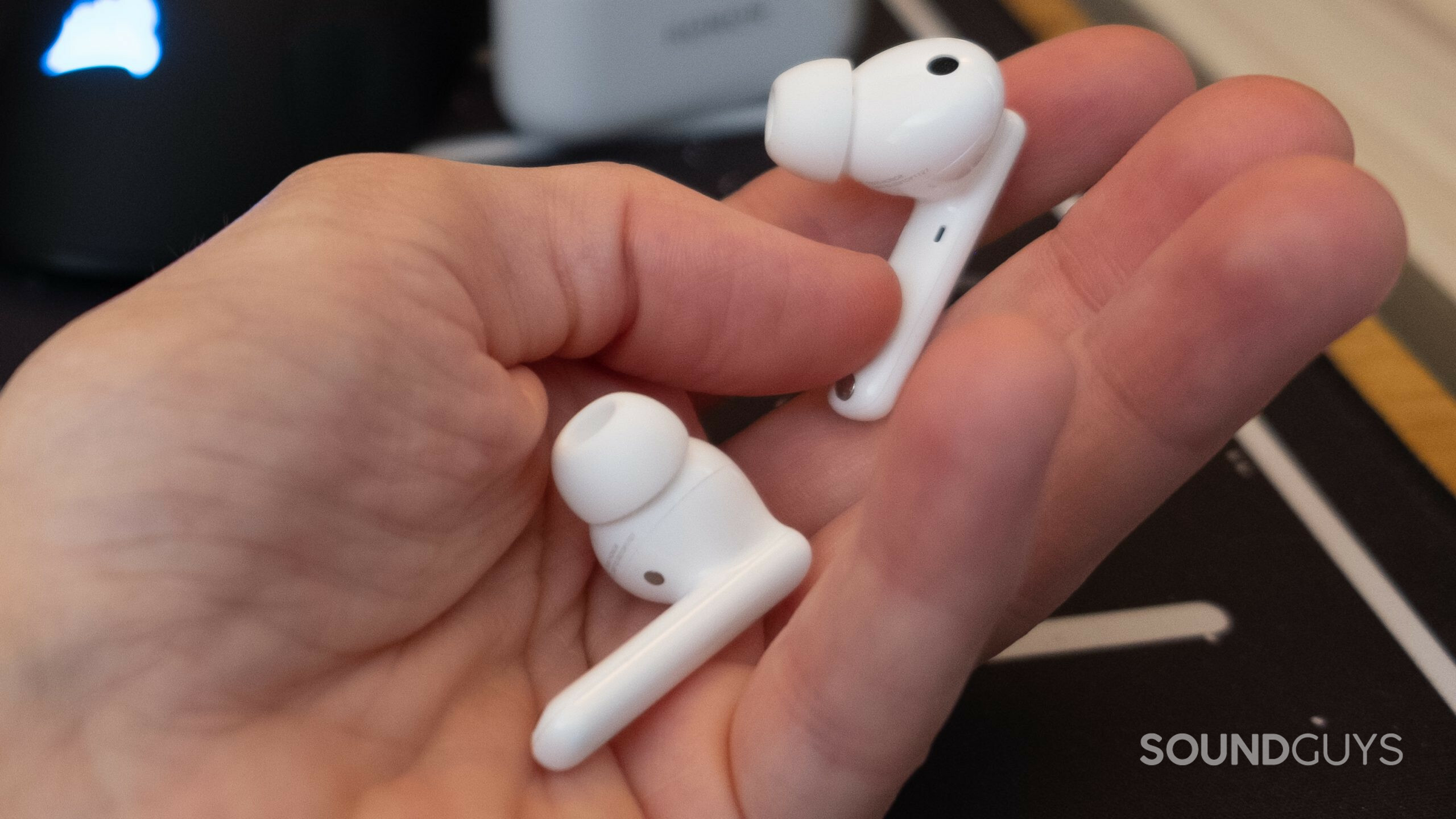 a hand holds honor earbuds 2 lite