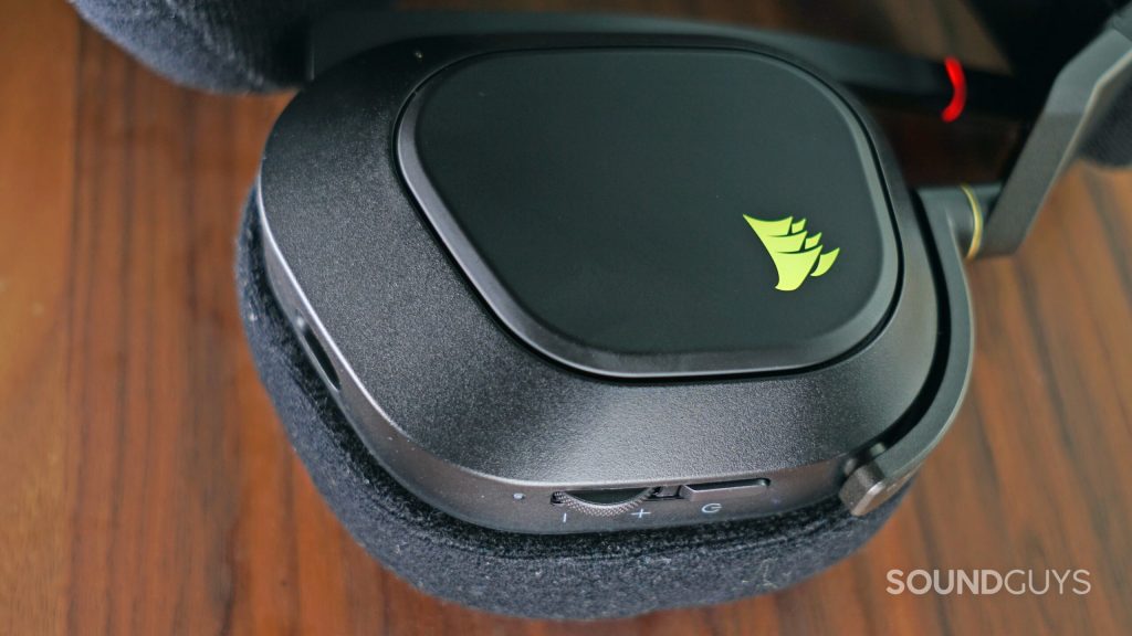 A close-up shot of the left headphone of the Corsair HS80 RGB Wireless, showing its controls.