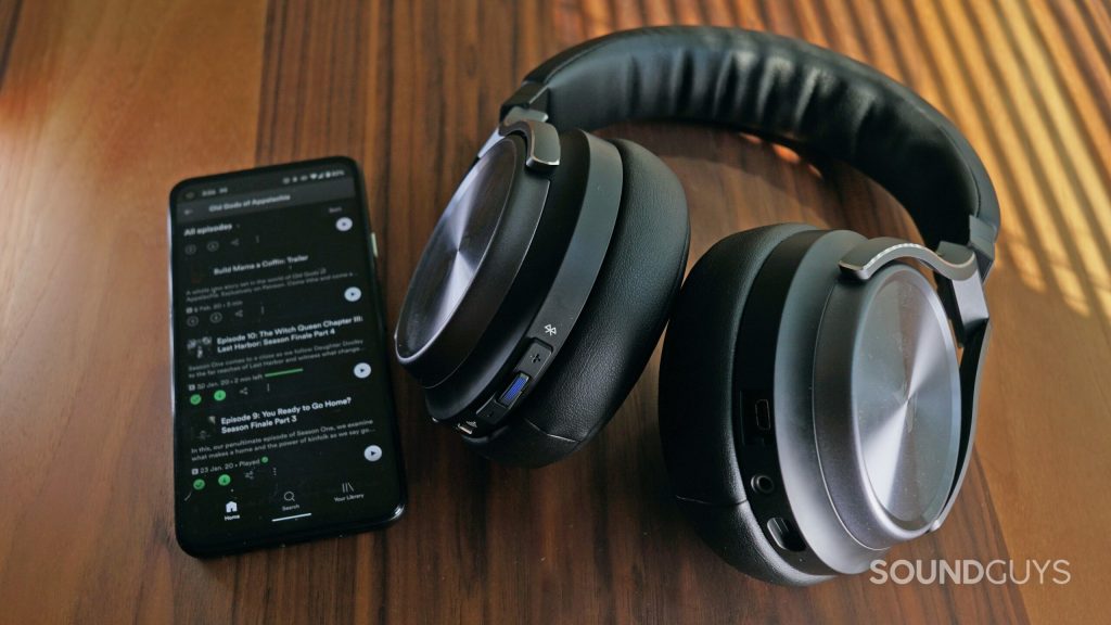 The Corsair Virtuoso RGB Wireless XT lays ona. wooden table next to a Google Pixel 4a.