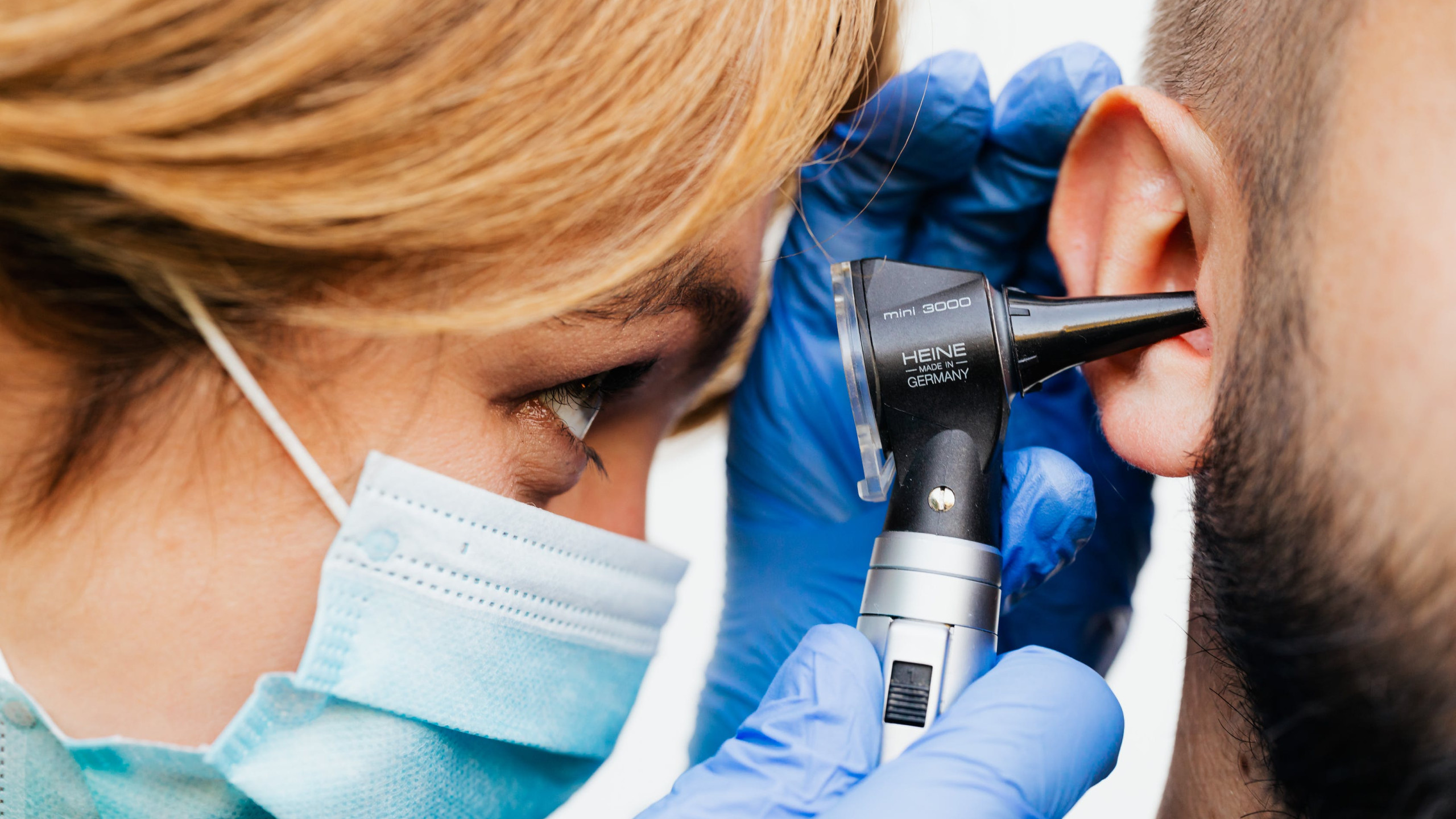 An ENT doctor examines a man's ear.