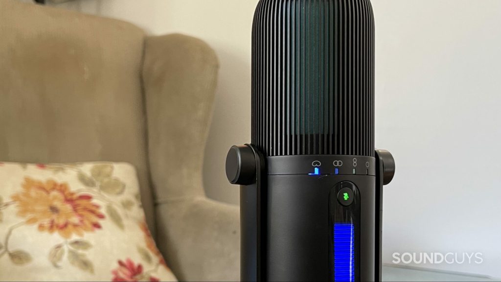 JLab Talk PRO USB microphone on a table with an armchair in the background.