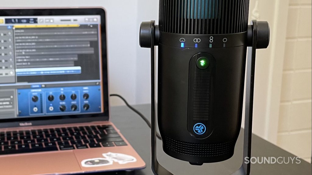 JLab Talk PRO USB microphone on a table with a laptop with a DAW open the background.