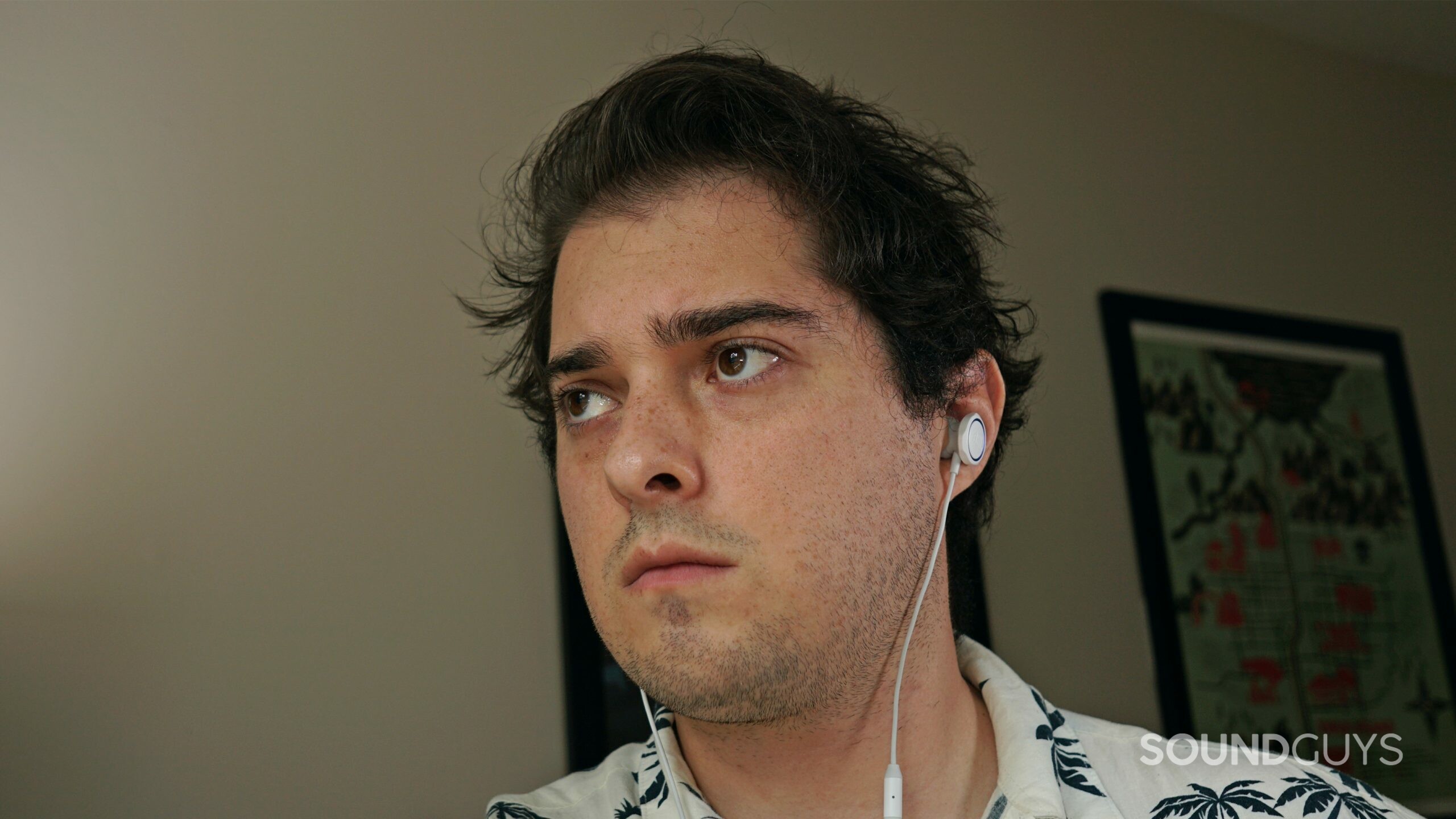 A man wears the JBL Quantum 50 gaming earbuds