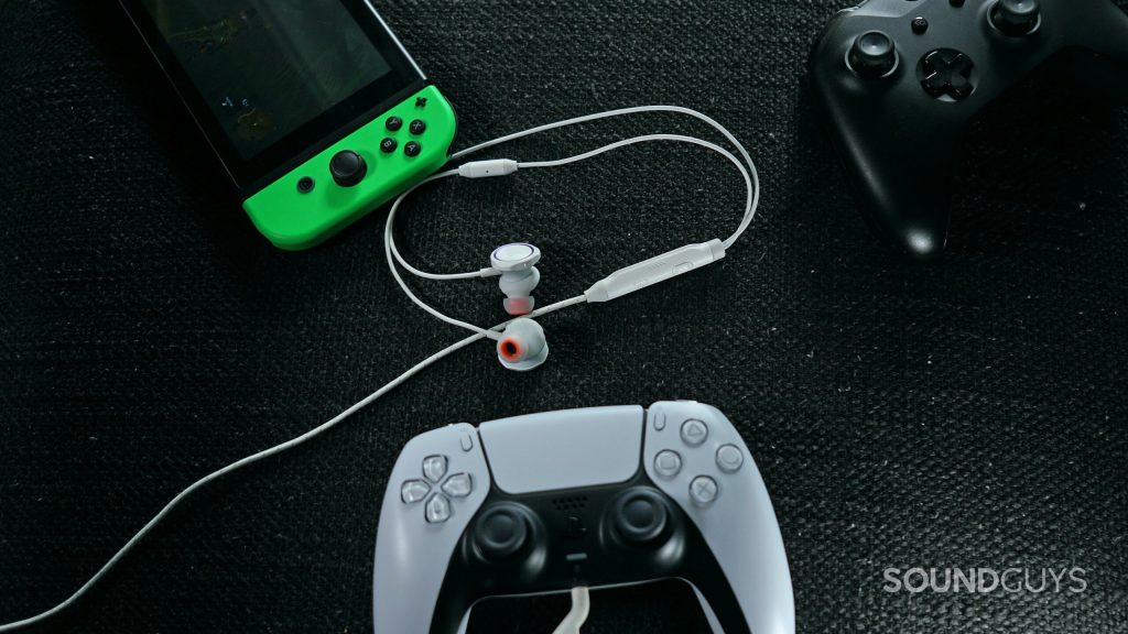 Le JBL Quantum 50 repose sur une surface en tissu entourée d'une manette Xbox One, d'une Nintendo Switch et d'une manette PlayStation Dualsense.