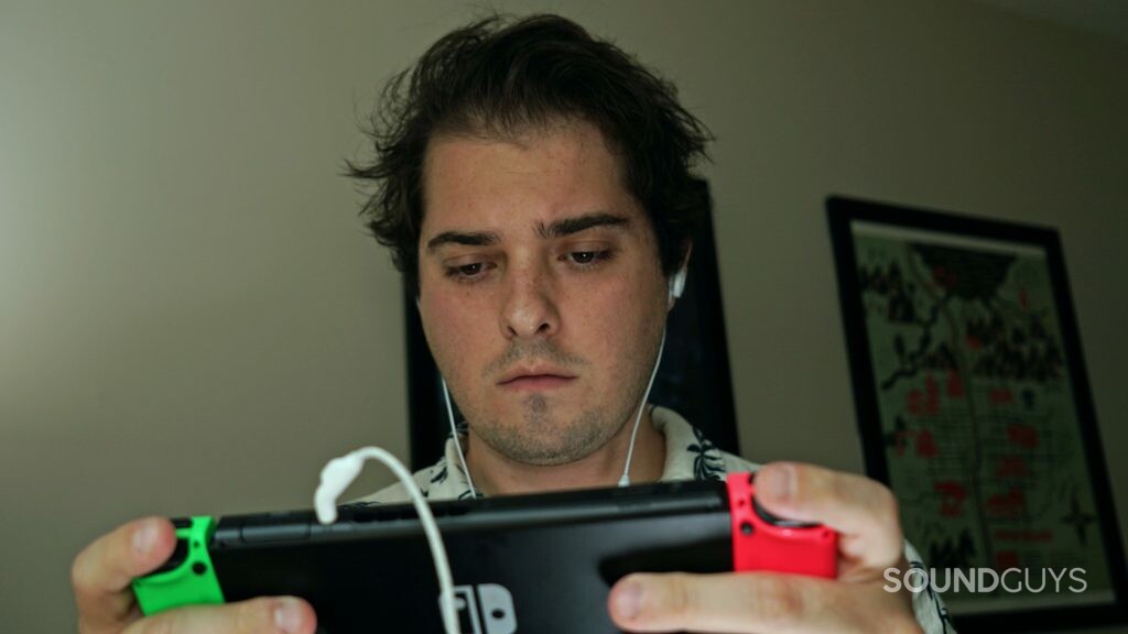 Un homme porte le JBL Quantum 50 en jouant sur Nintendo Switch.