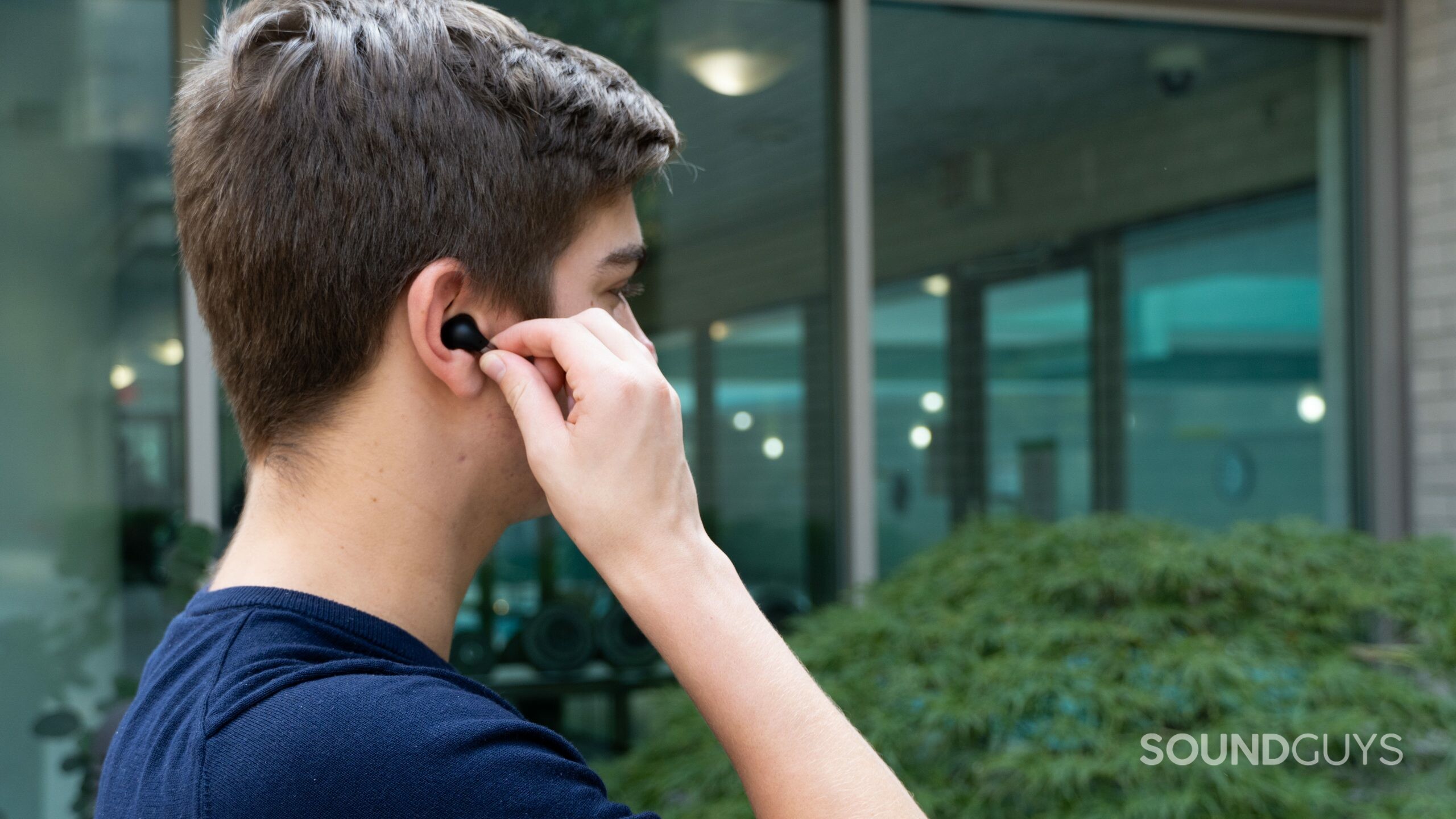 Person squeezing the stem on the OnePlus Buds Pro.