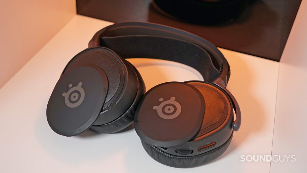 The SteelSeries Arctis Prime lays on a shelf with its magnetic face plates partially detached.