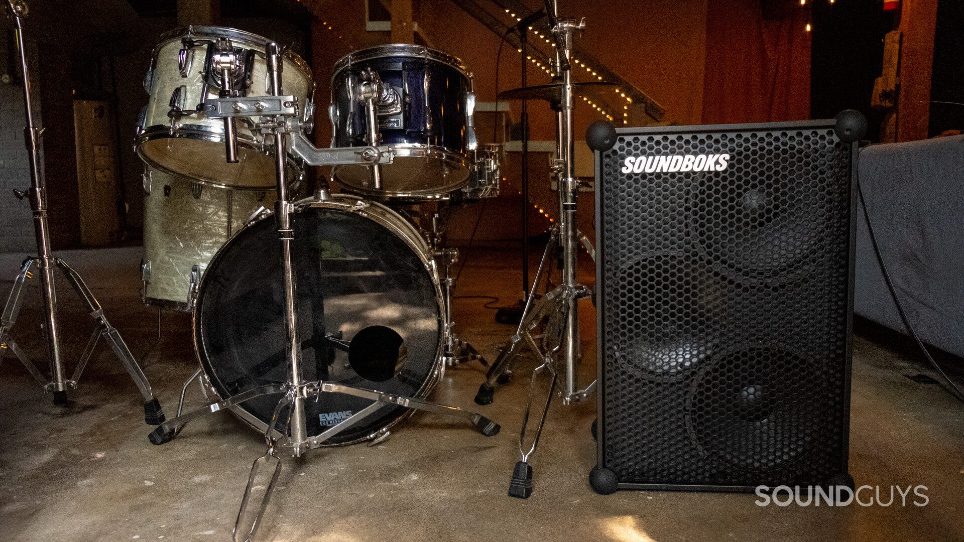 Front of SoundBoks (Gen. 3) beside a drum kit.