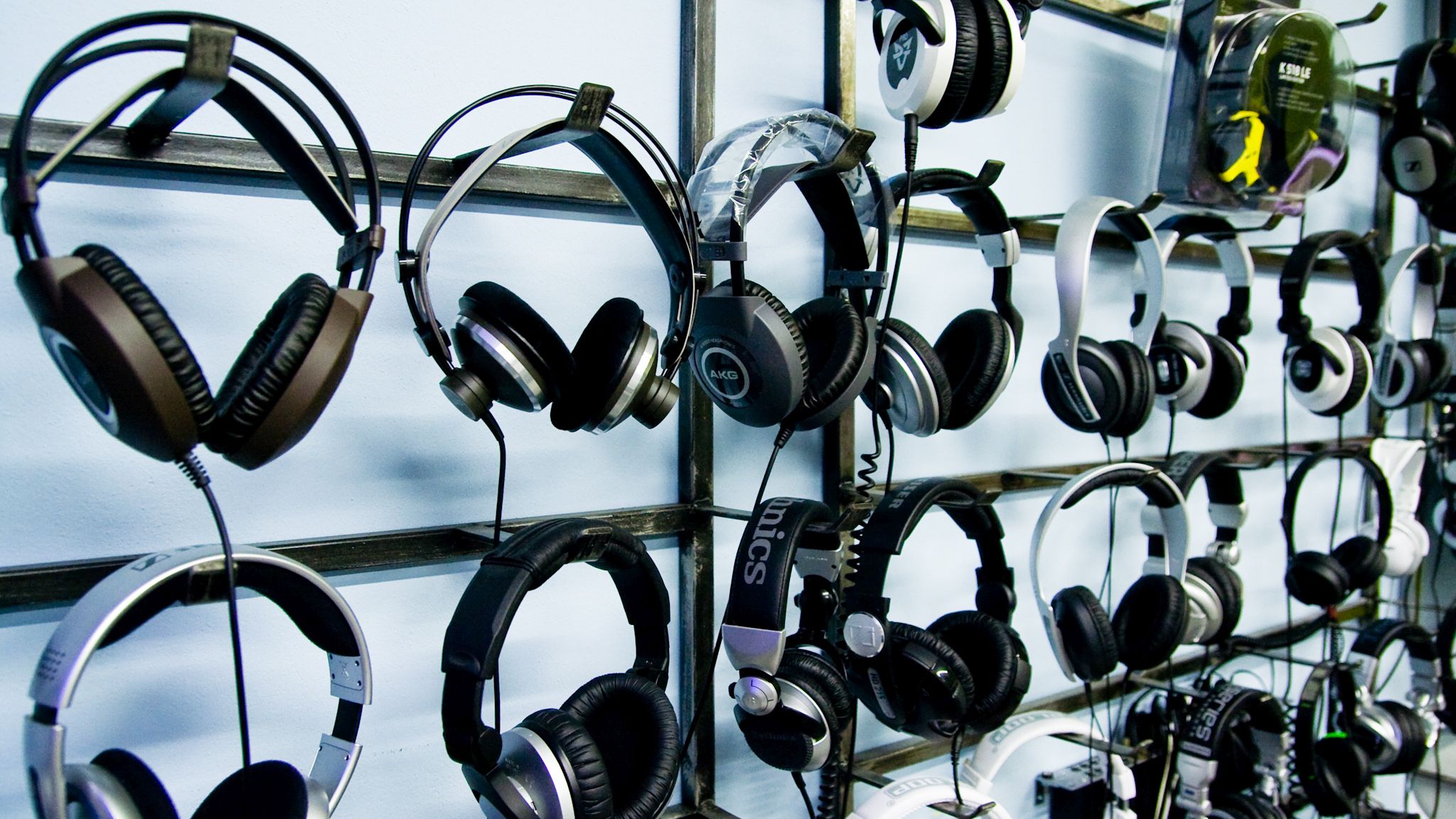 A display of used headphones for sale at a second hand store.